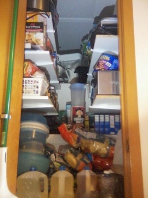 Attic access converted to a pantry with shelving loaded.
